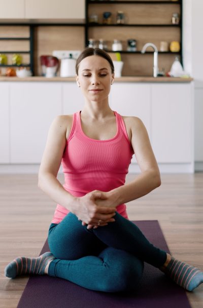 Young woman practicing yoga at home on the kitchen background